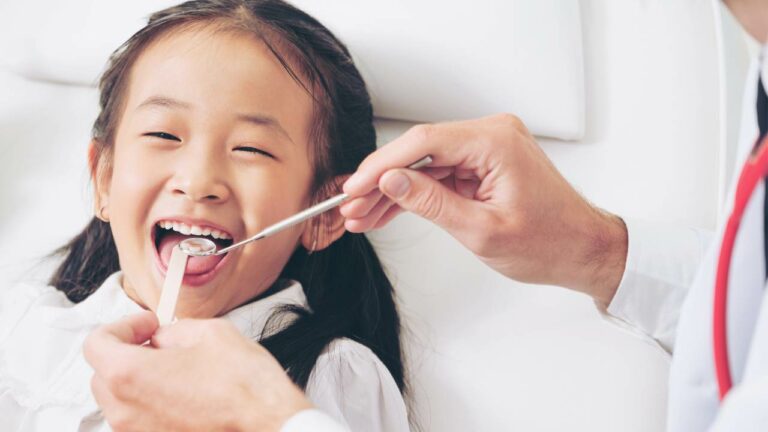 Menina fazendo consulta com dentista infantil.