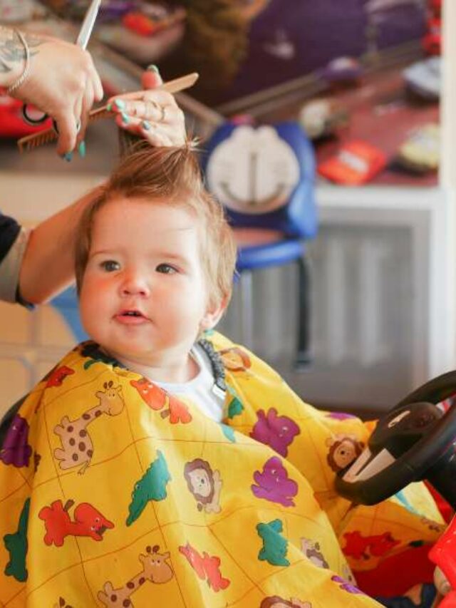 Bebê cortando o cabelo em salão de cabeleireiro infantil.