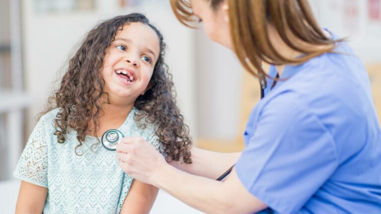 Garotinha sendo consultada com médica pediatra.