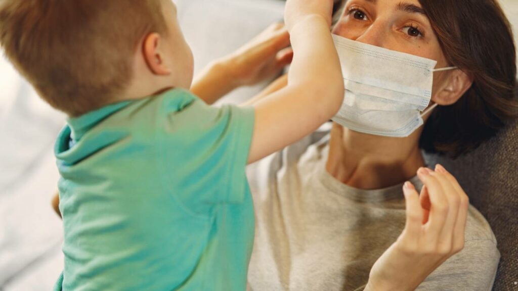 Criança colocando mascara em mãe.