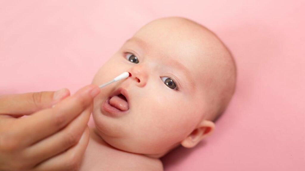 Limpando o nariz do bebê com cotonete.